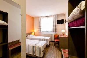 una camera d'albergo con due letti e una finestra di Hotel Le Lumière a Lione