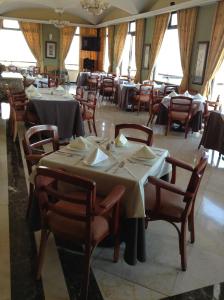 Hotel Real de Uruapan في اروابان دل بروغرسو: غرفة طعام مع طاولات وكراسي في مطعم