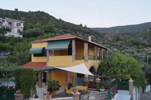 a large yellow house with a mountain in the background at Villa Sofia in Parga