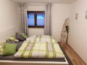 Cama en habitación con ventana en Ferienwohnung Karola, en Bad Bocklet
