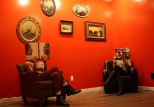two people sitting in chairs in a room with an orange wall at Apple Hostels of Philadelphia in Philadelphia