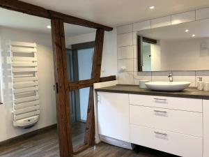 a bathroom with a sink and a mirror at La Stube de Marinette 5 étoiles in Hipsheim +53 photos