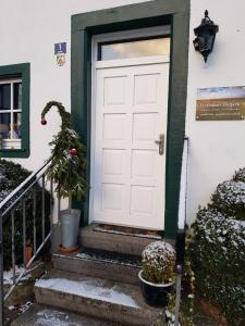 a white door on a house with a christmas tree at Ferienhaus Eifelperle in Blankenheim