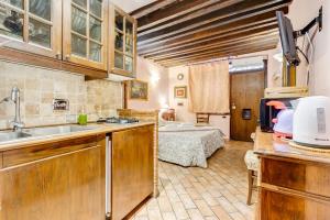 Una cocina con fregadero y una cama en una habitación. en Colosseum Rione Monti 1, en Roma