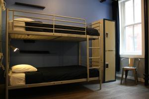 a bunk bed room with two bunk beds and a chair at Apple Hostels of Philadelphia in Philadelphia