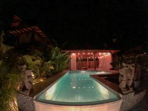 a swimming pool in a yard at night at Lua Villas in Santa Teresa Beach