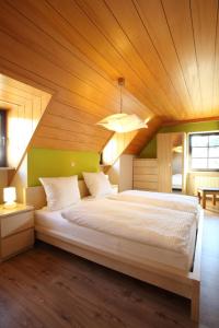 a bedroom with a large bed with a wooden ceiling at Gasthof Berghof in Presseck