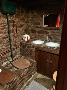 un bagno in pietra con due lavandini e uno specchio di Casa do Tanque a Lousã