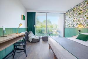 a bedroom with a bed and a desk and a window at Center Parcs Les Bois Francs in Verneuil d'Avre et d'Iton