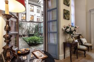 a room with a door and a table with a vase of flowers at Milano Antica Apartment in Milan
