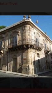 an old stone building with a balcony on a street at La tua casa al Mare in Eraclea Minoa