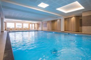 - une grande piscine d'eau bleue dans un bâtiment dans l'établissement Résidence Club MMV L'Altaviva, à Tignes