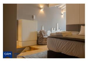 a bedroom with a bed and a cabinet and a chair at ORM Praça Apartment in Porto