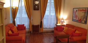 uma sala de estar com dois sofás e cortinas cor de laranja em Transparent Marais em Paris