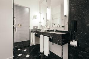 a black and white bathroom with two sinks and towels at Hotel Borg by Keahotels in Reykjavík