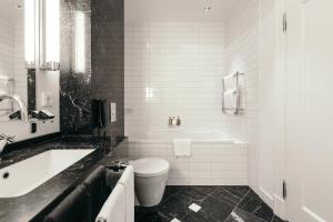 a black and white bathroom with a tub and a toilet at Hotel Borg by Keahotels in Reykjavík