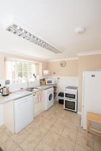 a kitchen with white appliances and a white refrigerator at Stable Cottage in Bardon Mill