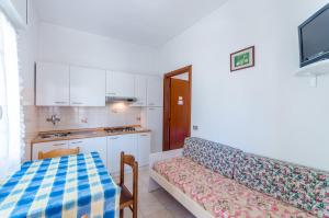 a living room with a couch and a kitchen at Appartamenti Calligher in Bibione