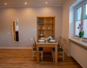 - une salle à manger avec une table et des chaises en bois dans l'établissement Apartament Przy Deptaku, à Wisła