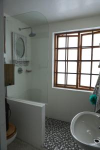 a bathroom with a tub and a sink and a mirror at Milkwood Way in St Francis Bay