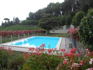 una piscina en un jardín con flores en RESIDENCE IL VIGNETO, en Lari