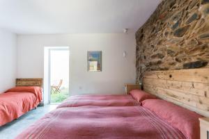 2 letti in una camera con parete in pietra di Casa de las Letrinas Baja, 2 Habt 5 más 1 Pers max chimenea con horno a Puerto de la Laja Altre 71 foto