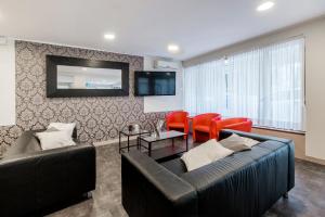 salon z kanapą i czerwonymi krzesłami w obiekcie HOTEL CONDOR w Rimini