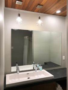 a bathroom sink with two faucets and a large mirror at Motel Le Martinet in La Pocatiere +76 photos