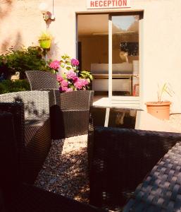 a patio with chairs and flowers in front of a building at Bungalows Filippi in Porto-Vecchio