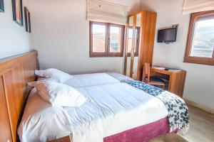 a bedroom with a bed with a desk and a television at Reinosa Atalaya-La Vega in Reinosa