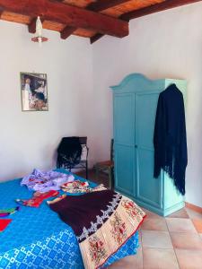 1 dormitorio con 1 cama y armario azul en Camisadu, en Oliena