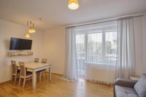 - un salon avec une table à manger et une fenêtre dans l'établissement Akva Apartament 1, à Druskininkai