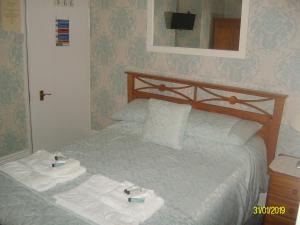 a bed room with a white bedspread and pillows at Kelvin House in Torquay