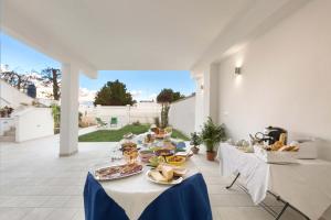 a long table with plates of food on it at B&B Dreams and Delights in Porto Cesareo