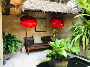 a patio with a couch and two red lanterns at Villa Elleo in Seminyak