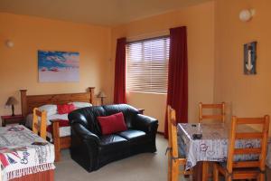 a bedroom with a chair and a bed and a window at The Timeless Way Self Catering Accommodation in Swakopmund