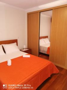 ein Schlafzimmer mit einem Bett und einem großen Spiegel in der Unterkunft Andrade Blue in Caniço