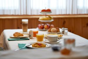 einen Tisch mit Frühstückszutaten und Getränken darauf in der Unterkunft Hotel Garni Sonnenhalde in Arosa