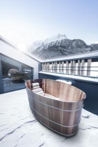 una vasca in legno seduta sopra un tetto di Glanz & Glory Längenfeld a Längenfeld