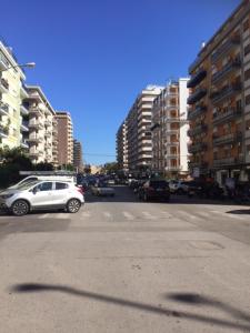 una strada cittadina con auto e edifici parcheggiati di Il gabbiano in città a Palermo
