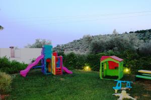 a yard with two play equipment in the grass at 4epoches in Steni Vala Alonissos
