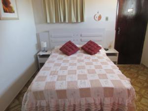 Un dormitorio con una cama con almohadas rojas. en Pousada Zenite, en Natal
