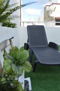 a black table and chair on a balcony at Little Surf House Hostel in Las Palmas de Gran Canaria