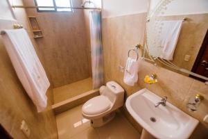 La salle de bains est pourvue de toilettes, d'un lavabo et d'une douche. dans l'établissement Hostal Sueños Silvestres, à Puerto Ayora