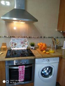 a kitchen with a stove and a washing machine at Calle Maliayo in Villaviciosa +7 photos