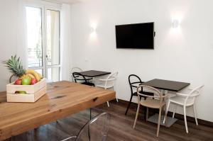 uma sala de jantar com mesa e cadeiras e uma televisão em HOMY BnB em Empoli