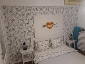 1 dormitorio con cama y pared con papel pintado en Victoria Avenue Apartment en Bucarest