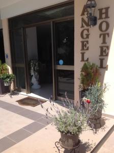 a vase with flowers in front of a building at Angela Hotel in Agia Marina Aegina