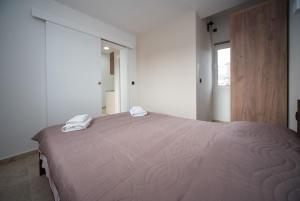 a bedroom with a large bed with two towels on it at Apartments Vila Monegro in Bar