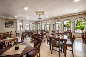 un restaurante con mesas, sillas y ventanas en Anamar Zante Hotel, en Argassi